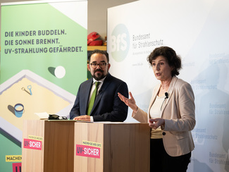BfS-Präsidentin Dr. Inge Paulini und der Parlamentarische Staatsekretär Christian Kühn an zwei Rednerpulten. Im Hintergrund ist ein Motiv der Kampagne zu sehen.
